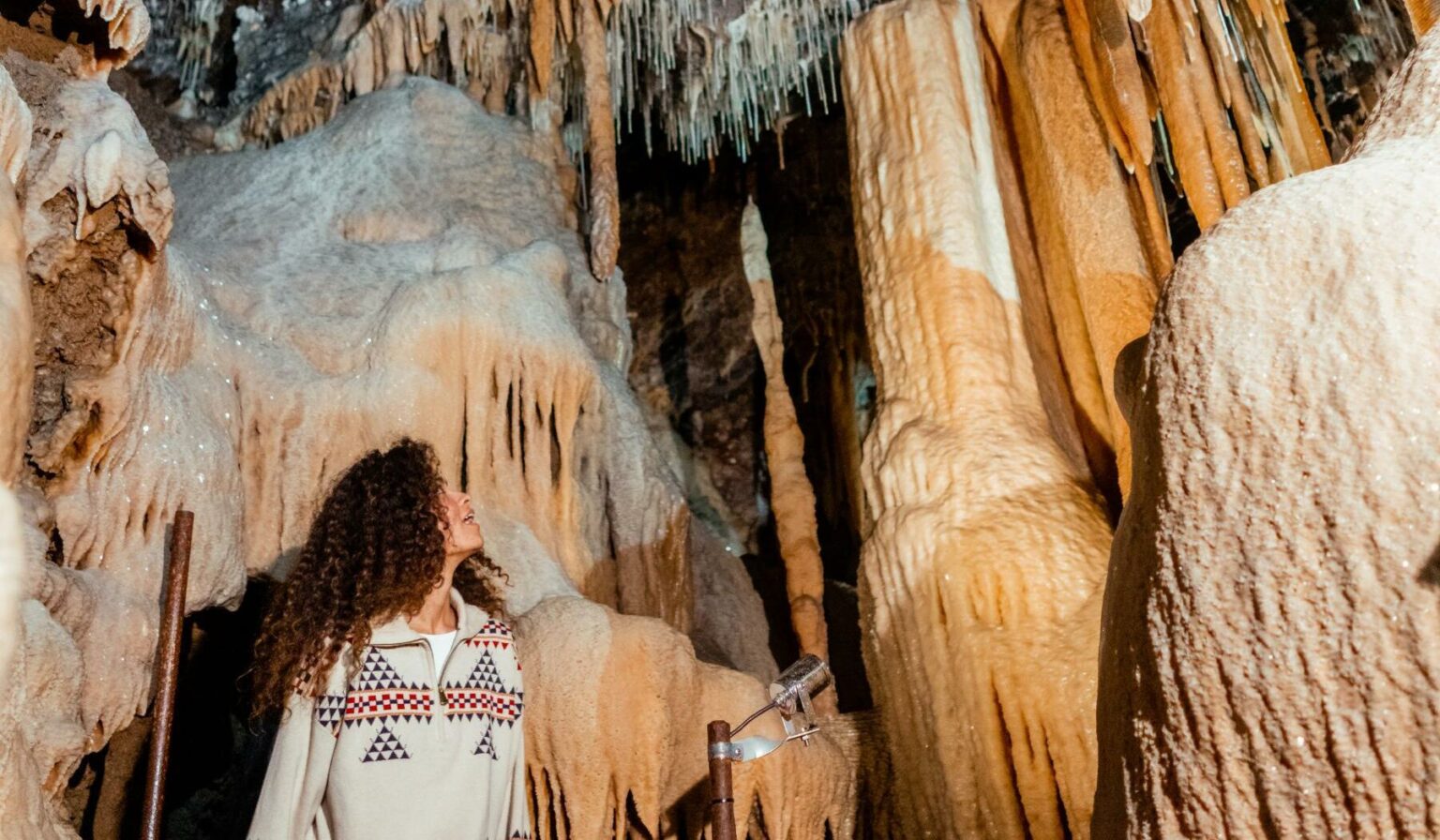 Buchan-Caves-girl-looking-up-at-stalactites-lit-up_d0fac39c089a8a5df7376751f4812439